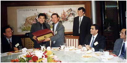 2001年10月， 胡伯橋會長於北京訪問時贈送紀念品給中國保險協會主席唐運祥先生